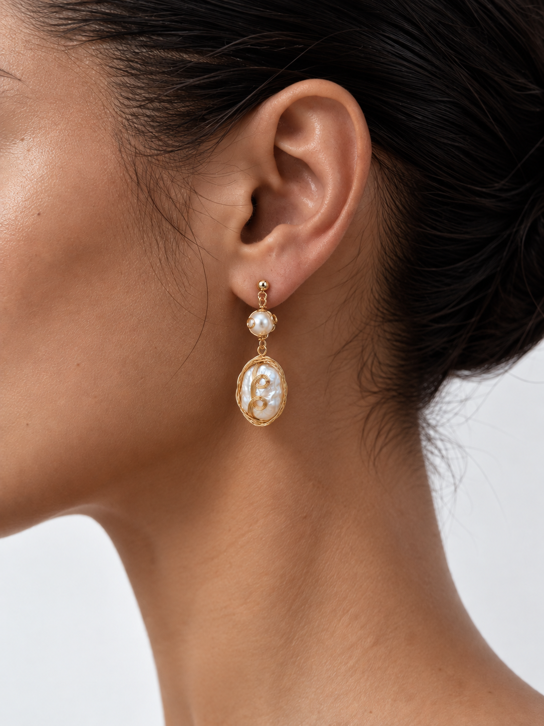 woman wearing baroque pearl drop earrings