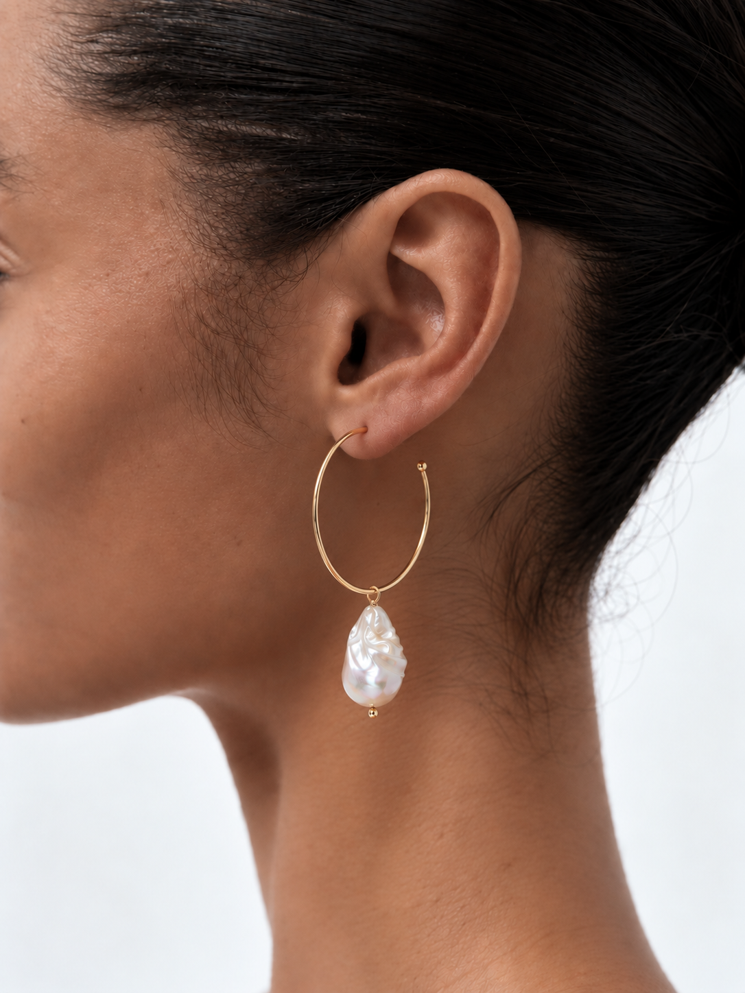 woman wearing baroque pearl hoop earrings