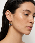 woman wearing black baroque pearl earrings