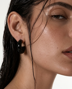 woman wearing black C-shaped hoop earrings