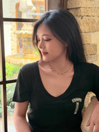 Black bead cross necklace worn