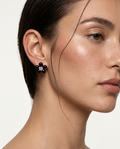 woman wearing black flower stud earrings