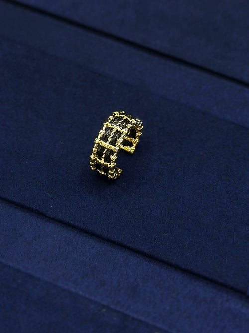 Intricate openwork detail on black and gold ring