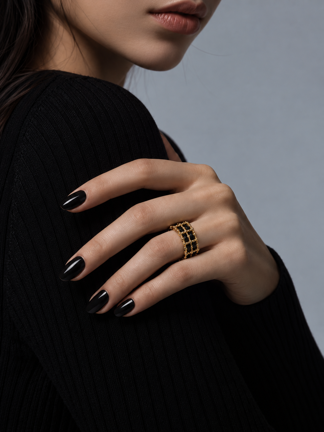 Black and gold openwork statement ring worn on finger