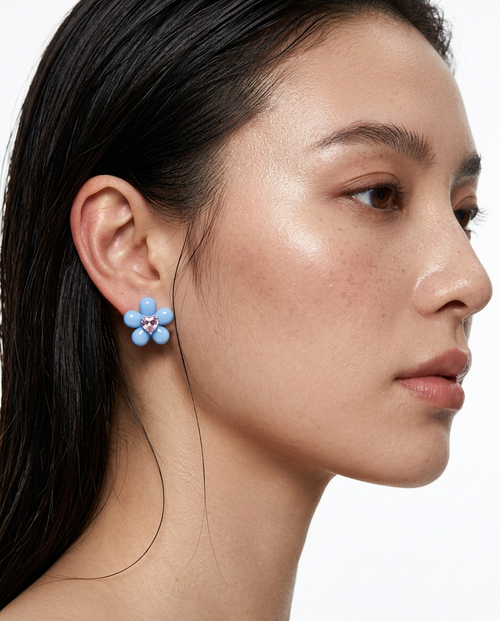woman wearing blue flower stud earrings