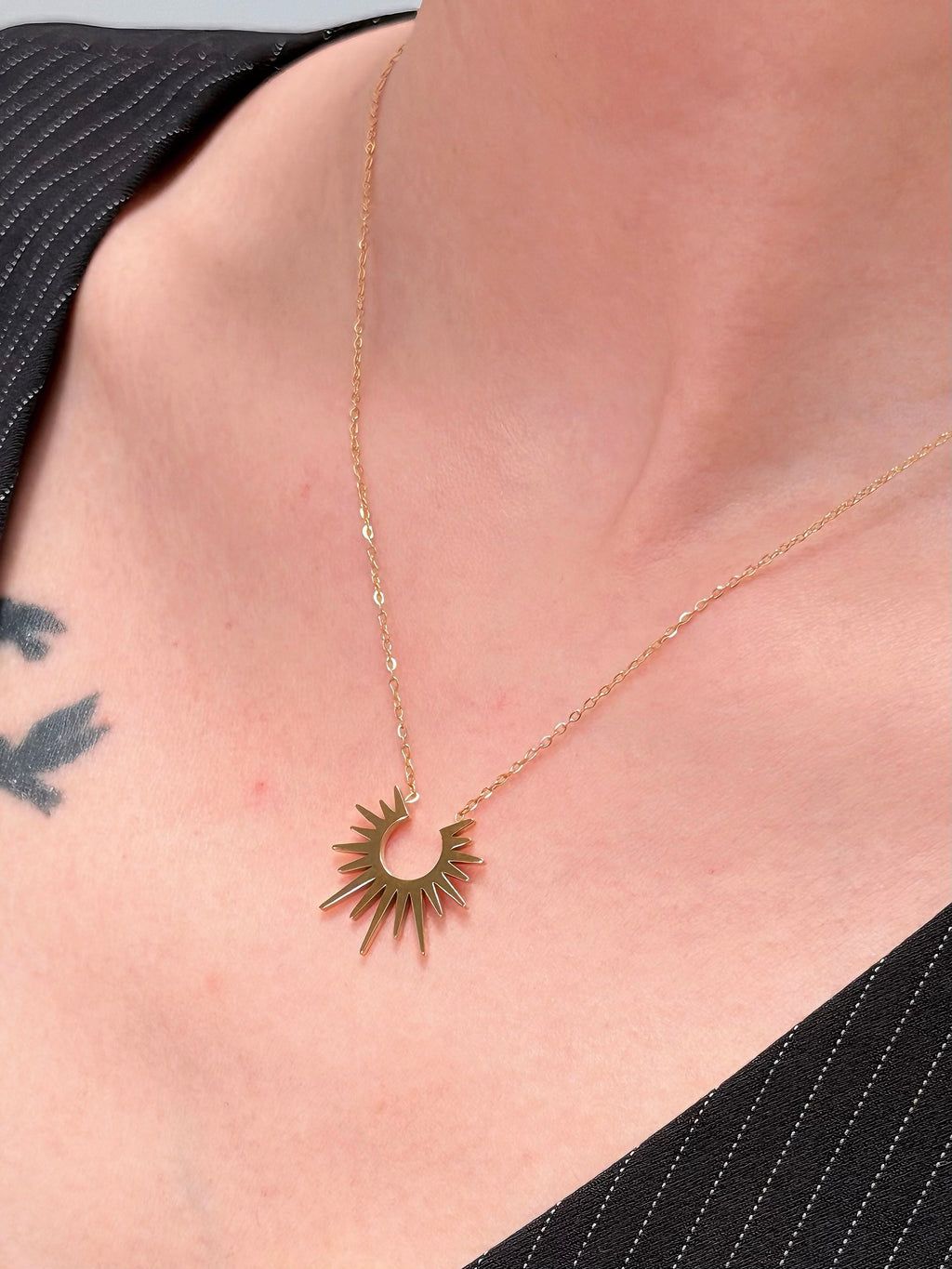 Delicate gold-tone chain with sunburst pendant