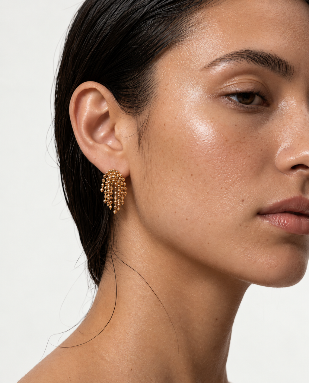 woman wearing gold beaded tassel earrings