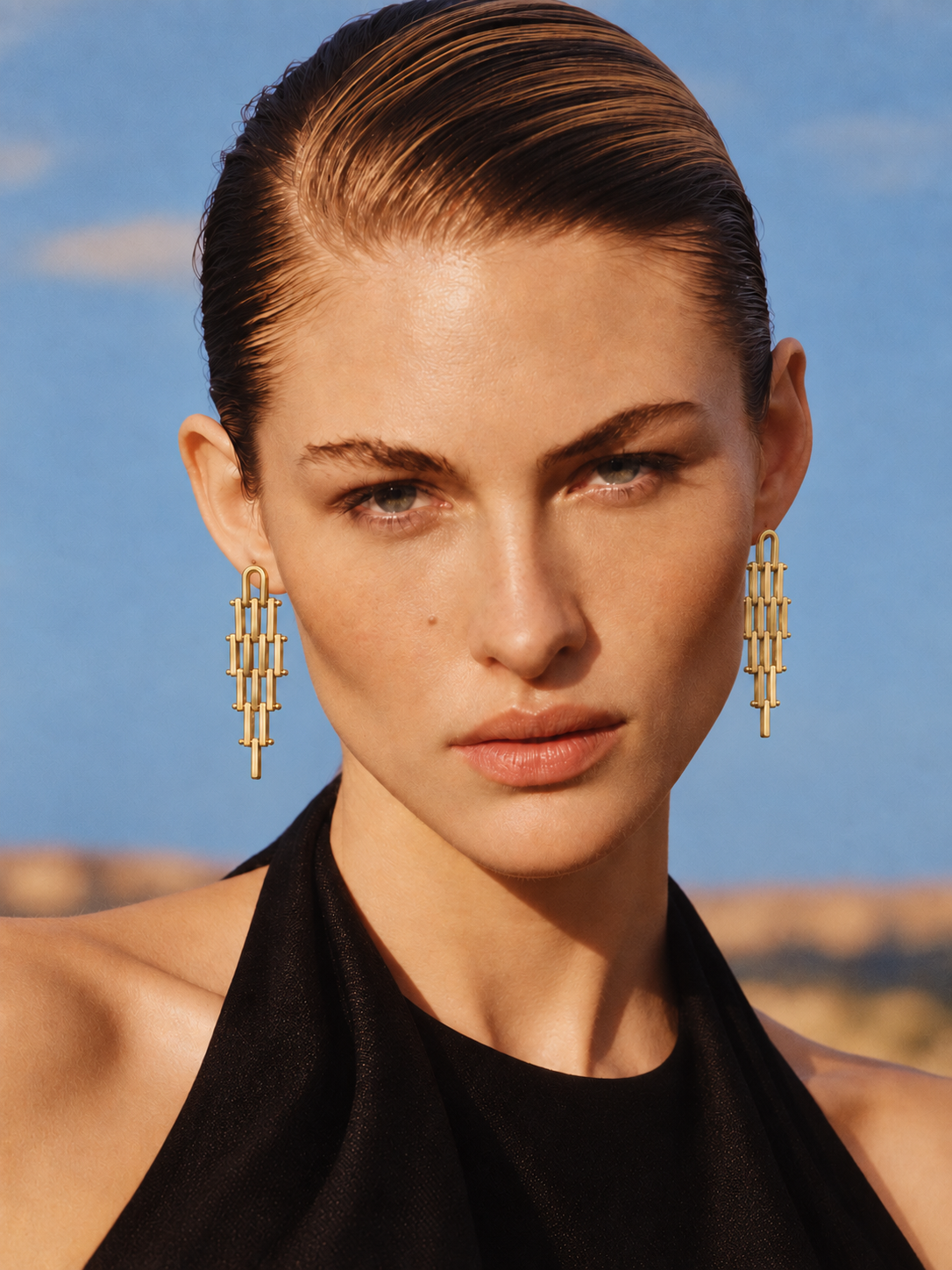 woman wearing long gold geometric drop earrings