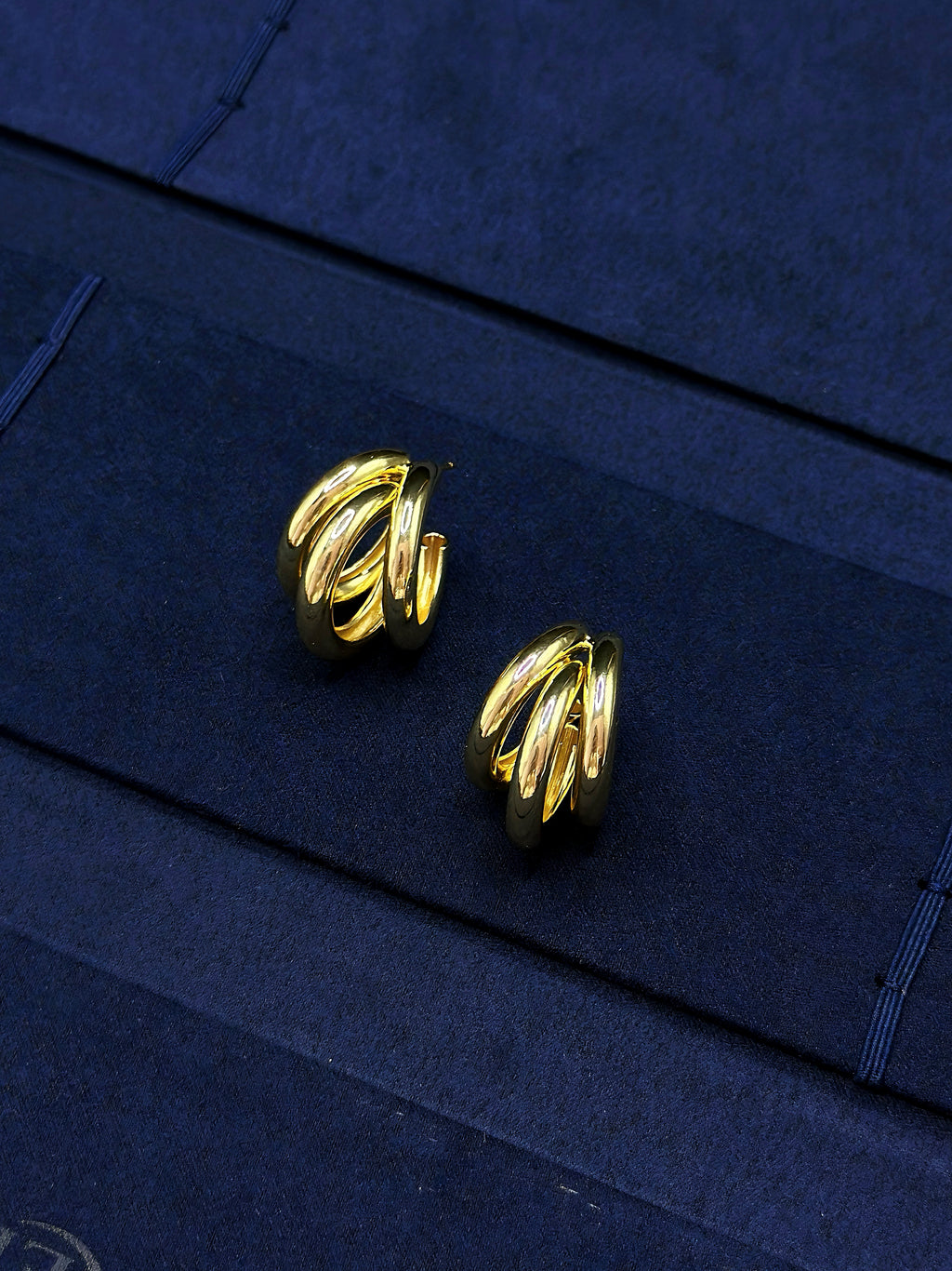 gold sculptural hoop earrings with curved metal lines