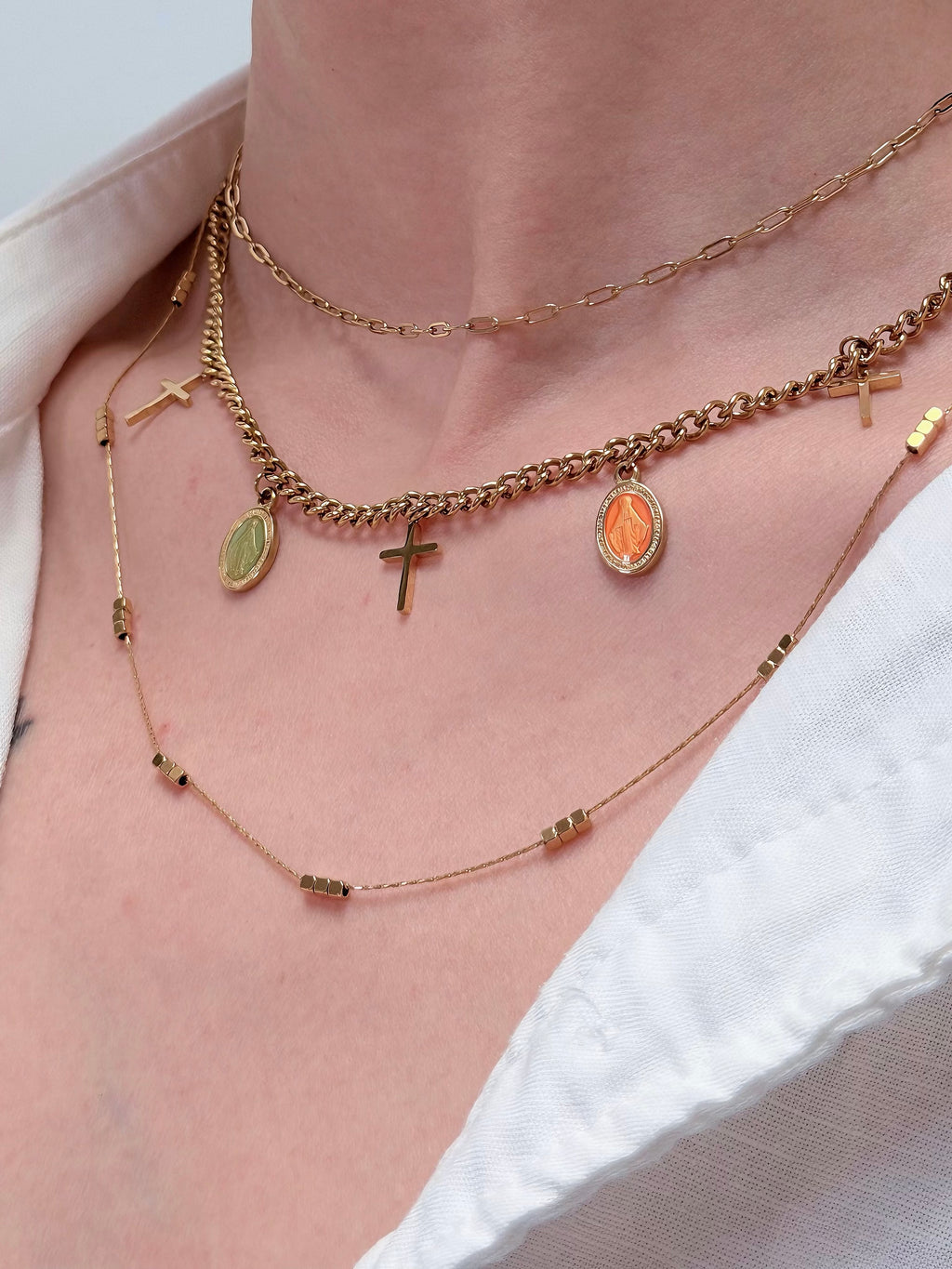 Gold cube chain necklace layered with delicate chains