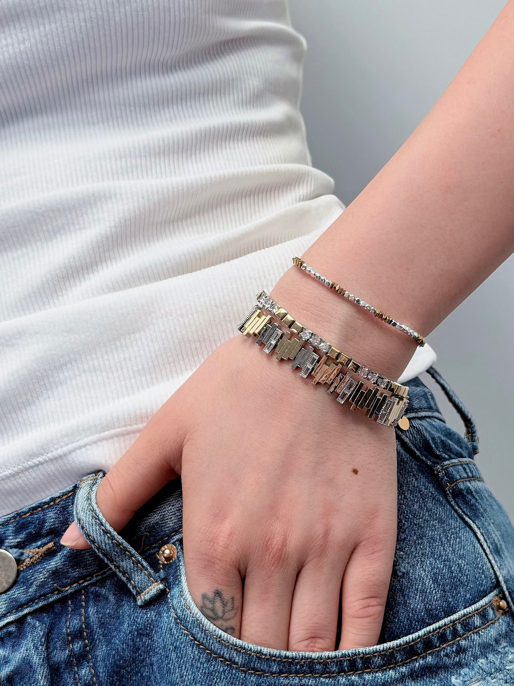 Layered silver metal bracelets with different textures