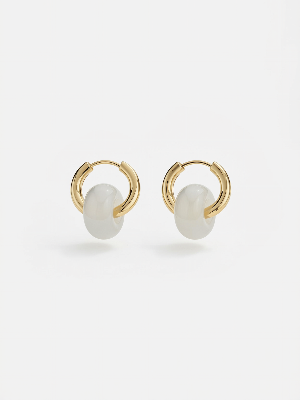 Close-up of gemstone detail on minimalist gold hoop earrings
