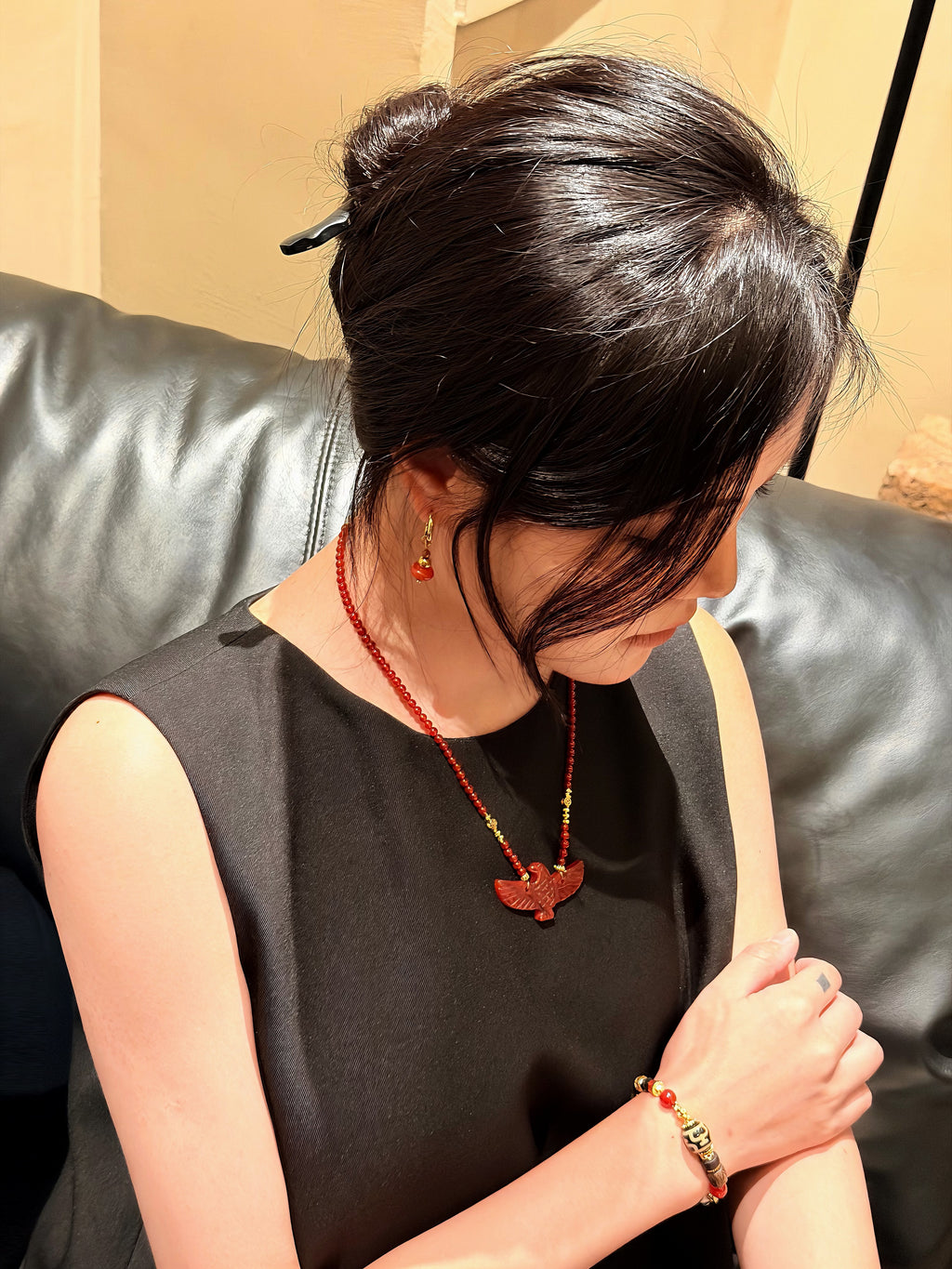 Natural red agate bird pendant necklace worn around the neckline