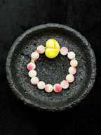 Full view of pink natural stone bracelet with pale yellow centerpiece