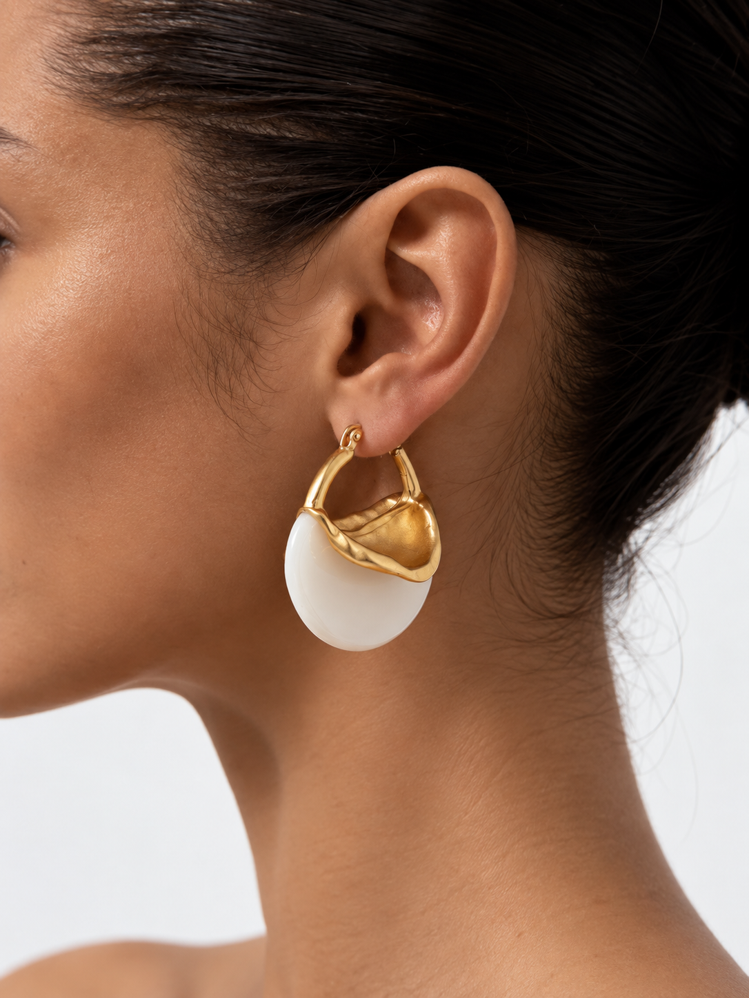 woman wearing sculptural gold arc earrings