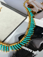 Sculptural gold-tone necklace detail