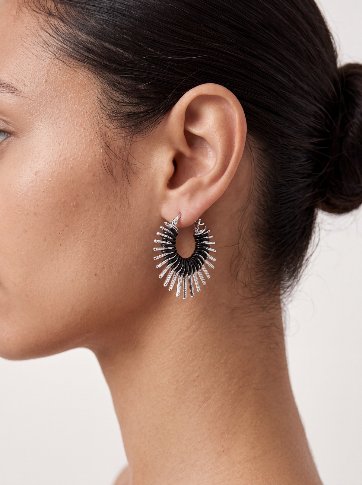 woman wearing sculptural silver heart earrings