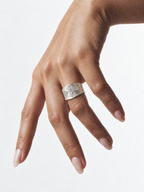 Silver cross statement ring worn on hand