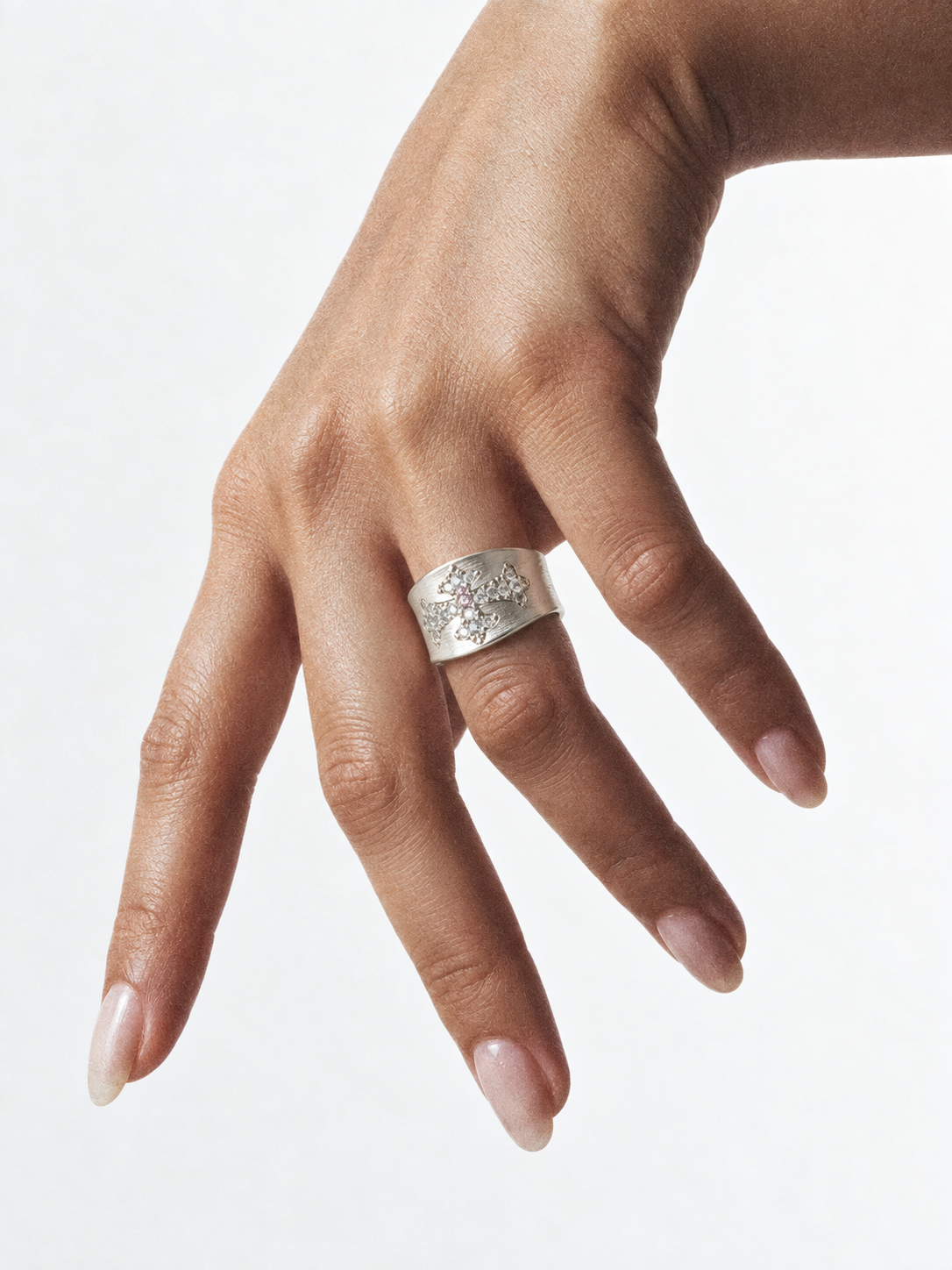 Silver cross statement ring worn on hand