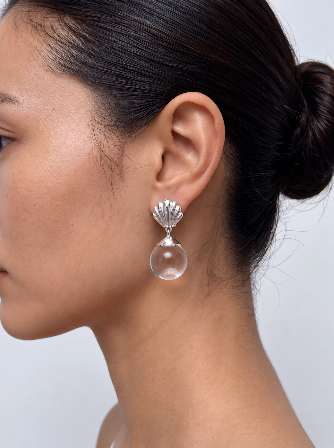 woman wearing silver fan earrings with crystal pendant