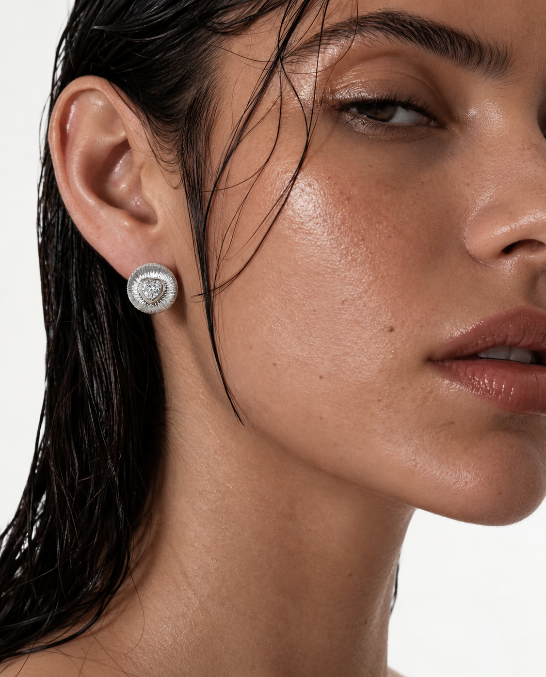woman wearing silver heart stud earrings
