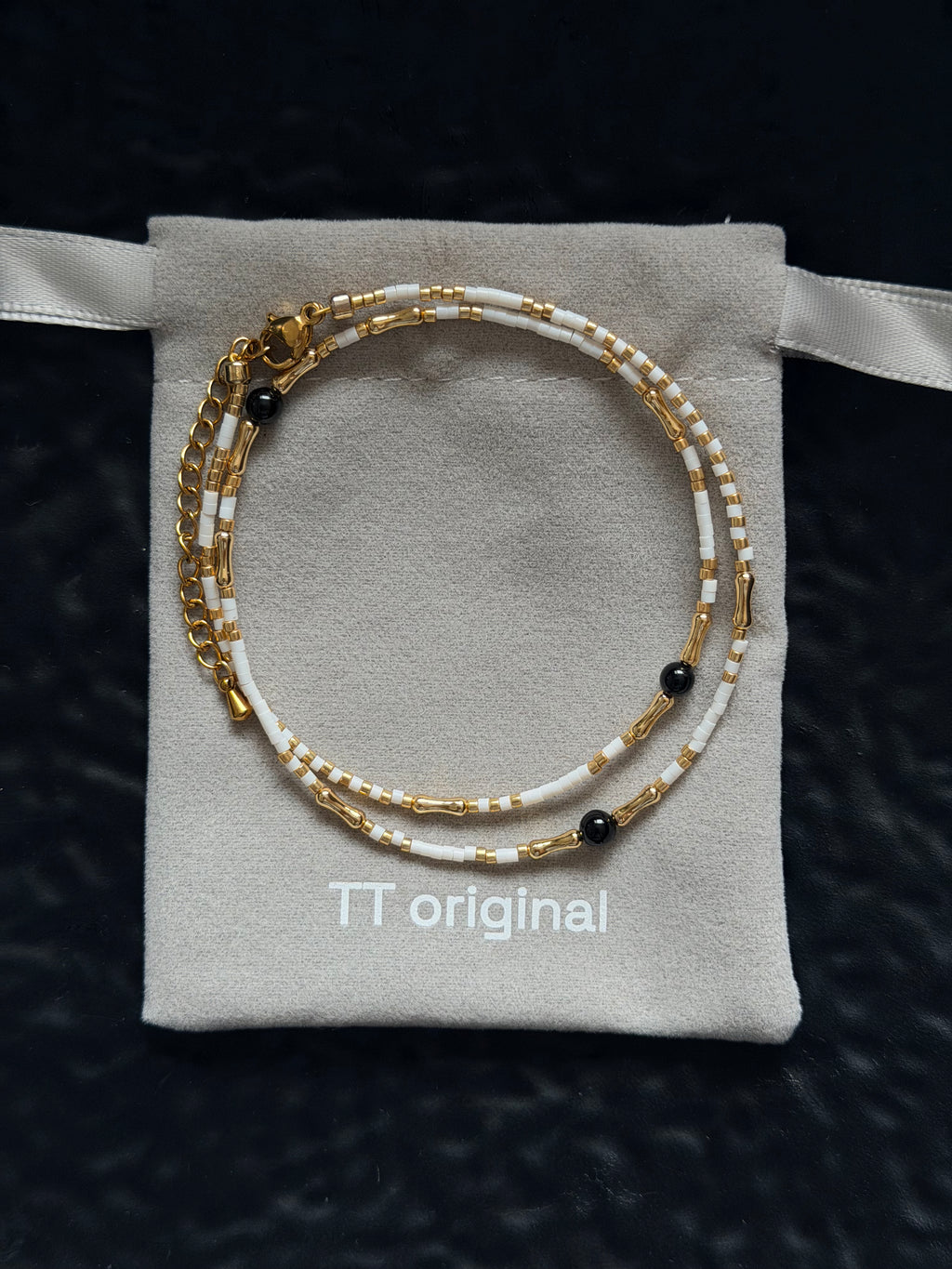 Close-up of white beads arranged along a delicate necklace