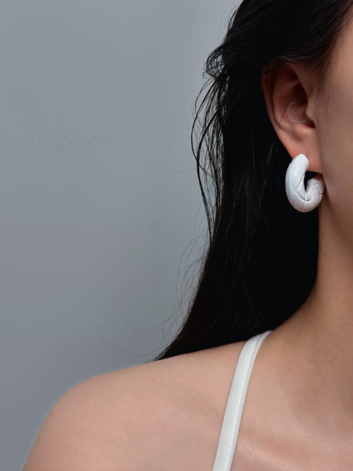 woman wearing white C-shaped hoop earrings