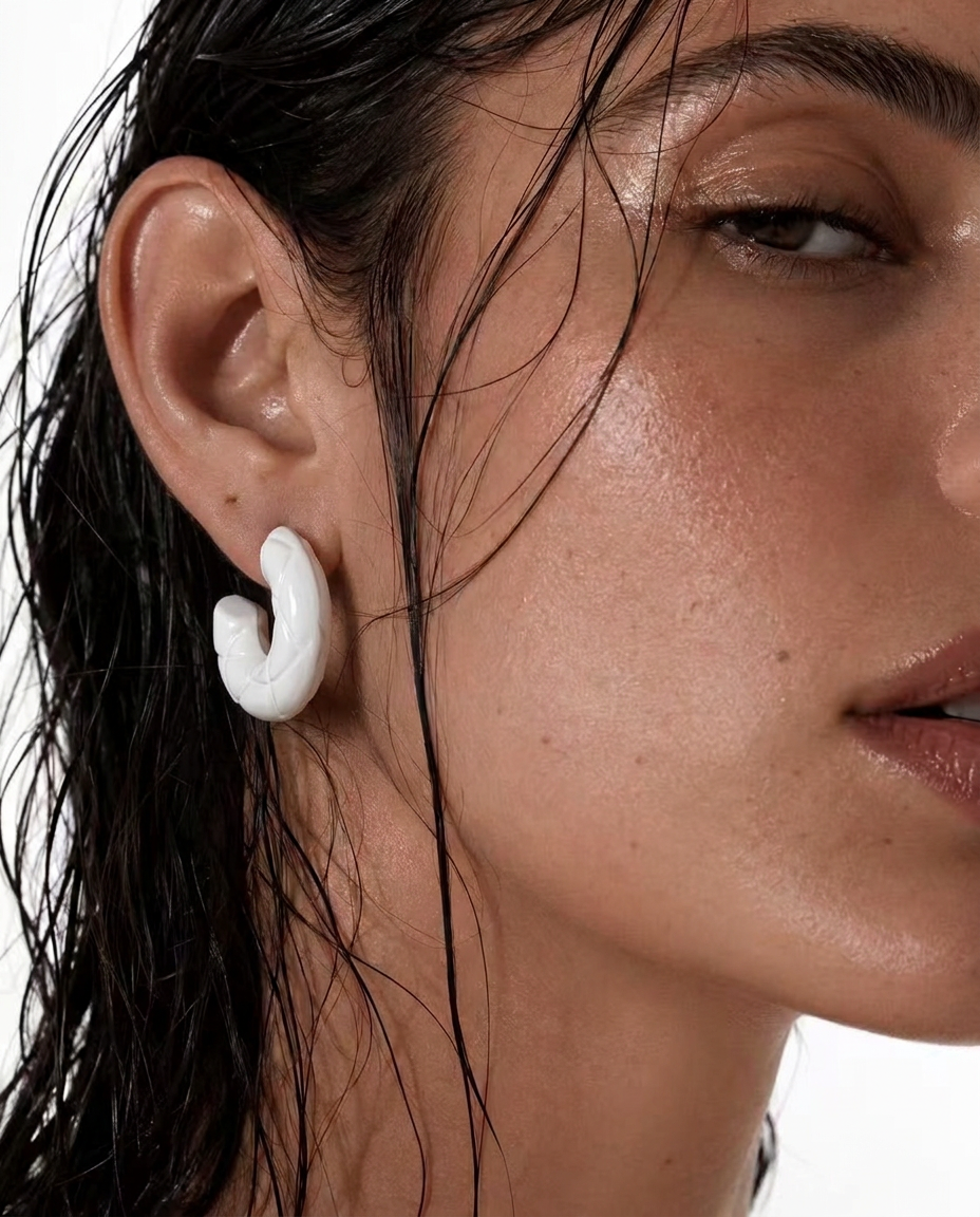 woman wearing white C-shaped hoop earrings