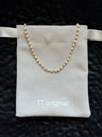 White enamel details on gold chain necklace