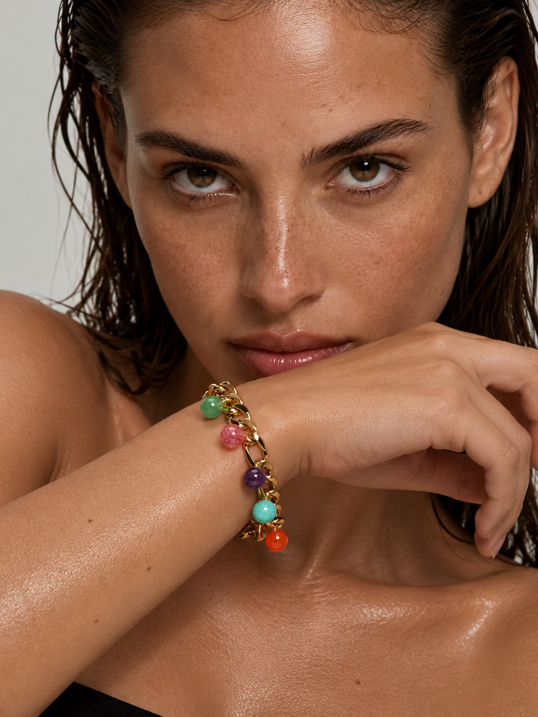 Woman wearing a chunky gold gemstone bracelet
